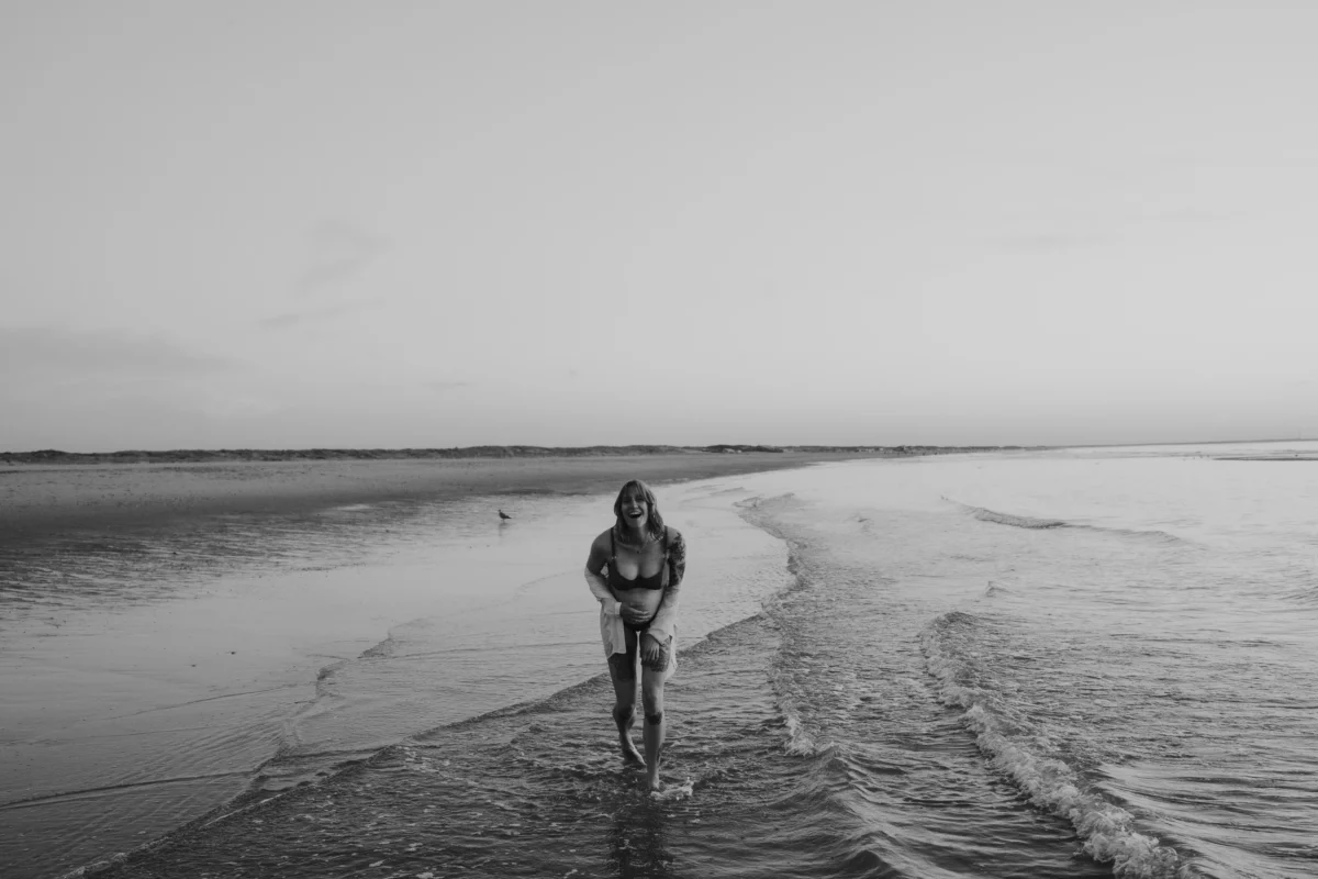 mooie zwangerschapsfotografie van een mama to be op het strand in de branding