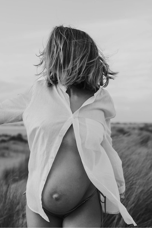Vrouw in wit overhemd, zwanger op de foto op de shoot van haar dromen