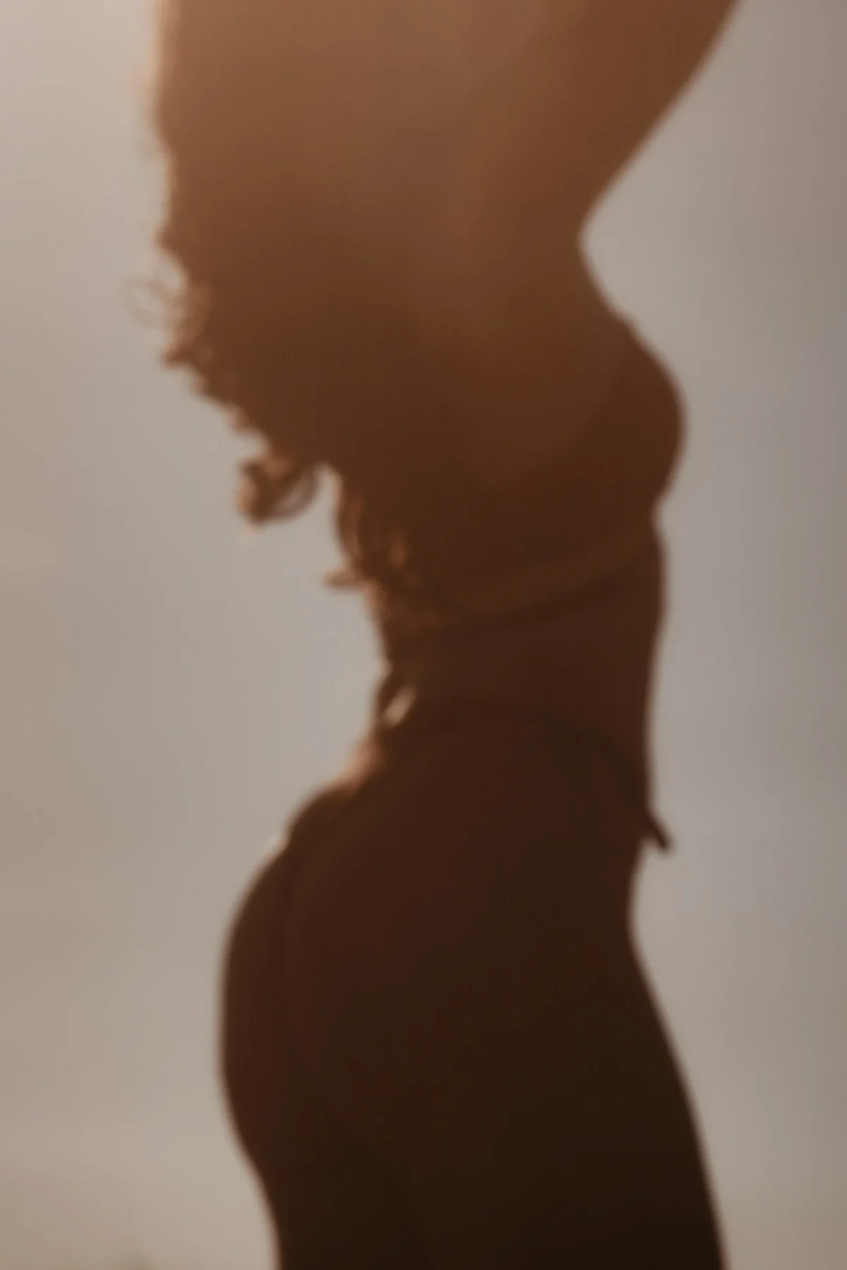 silhouette van een vrouw tegen een grijze achtergrond - boudoir fotografie in Nederland