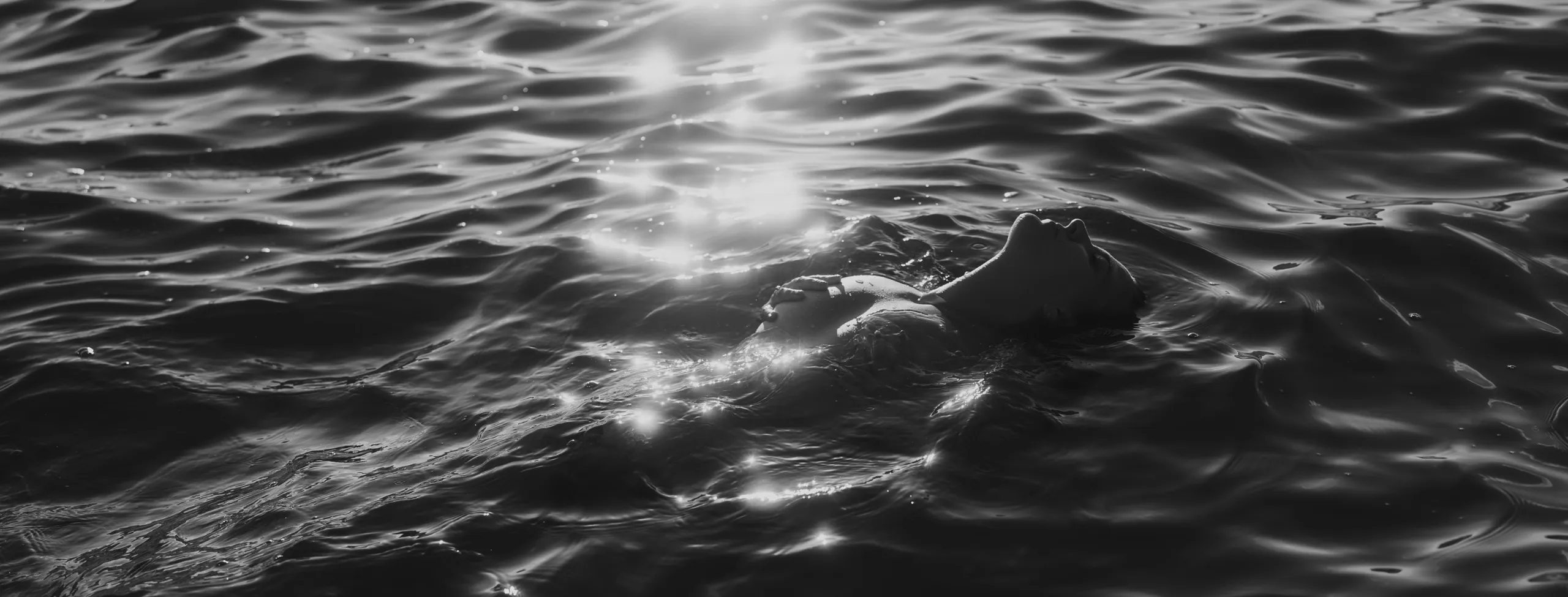 vrouw in zee omringd door water naakt bij boudoir shoot