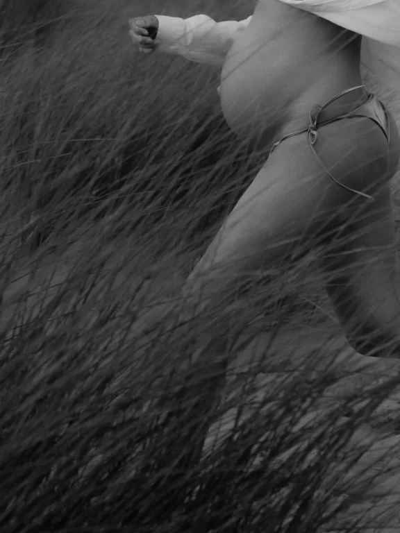 foto van zwangere vrouw in beweging in de duinen, vanaf buik te zien in zwart-wit, vitaliteit en feminiene energie staan centraal, wint award voor Shapes Shadows